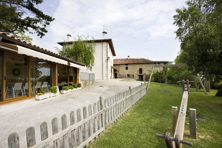 Casa rural Loretxea, Izkue, en las cercanías de Pamplona. Porche acristalado, zona de juegos infantiles y jardín :: Agroturismo en Navarra